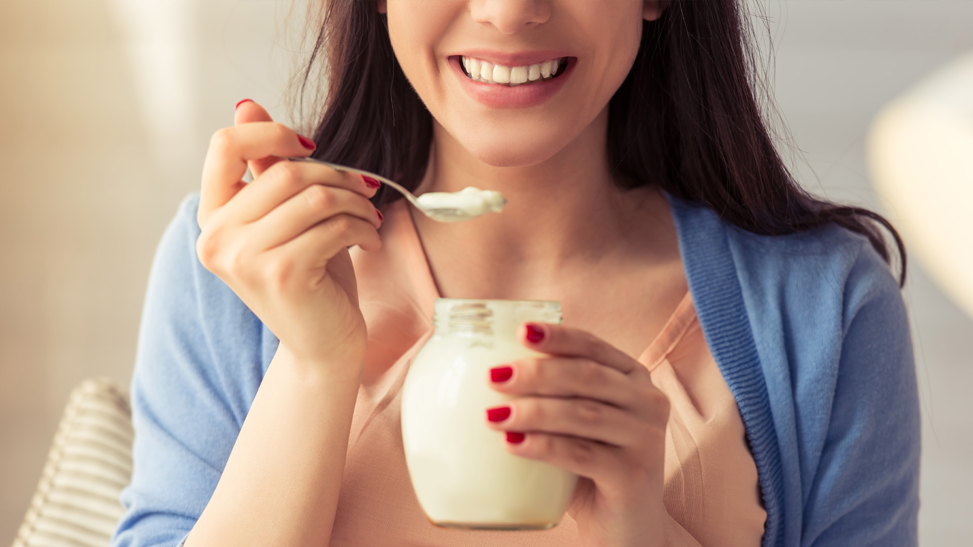 Woman eating oatmeal, smiling